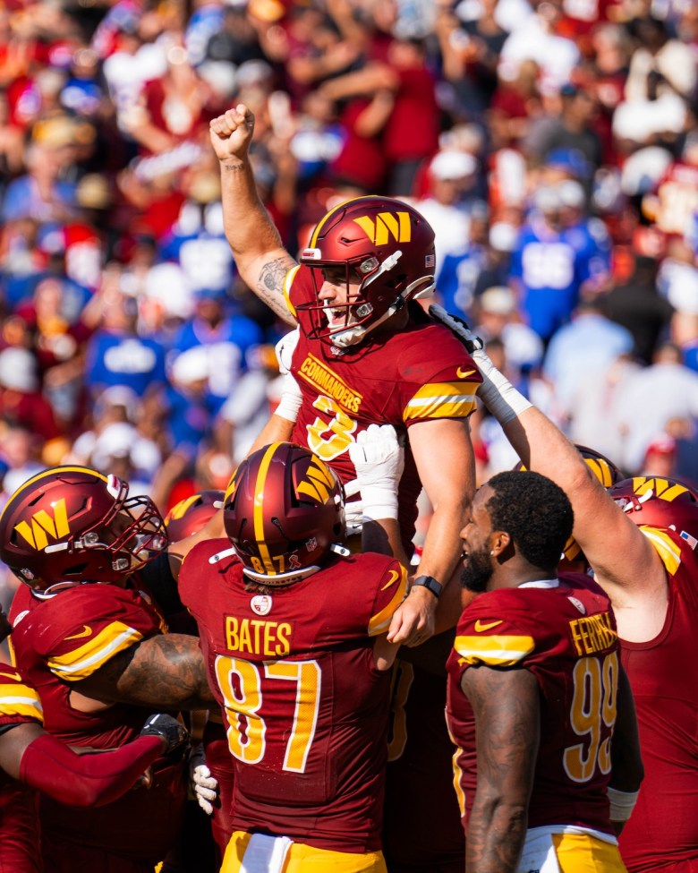 Commanders team holding up kicker Austin Seibert after his victory kick increases the final score to 21-18. (Abdullah Konte/The Washington Informer)